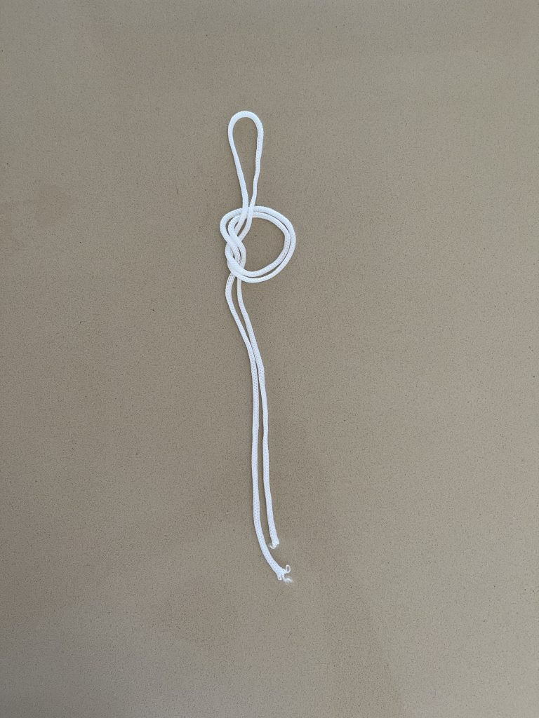 étape 3 du noeud de boucle en 8 avec une corde blanche pour faire des Nœuds Pour Moulinet de Pêche 
