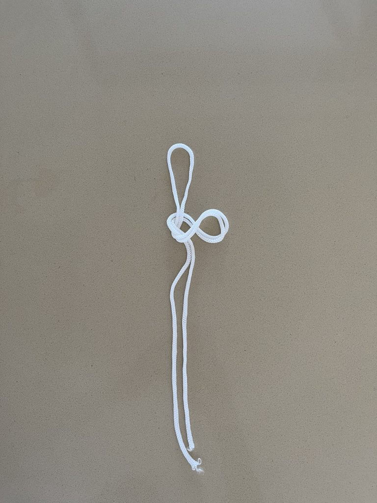 étape 4 du noeud de boucle en 8 avec une corde blanche pour faire des Nœuds Pour Moulinet de Pêche 