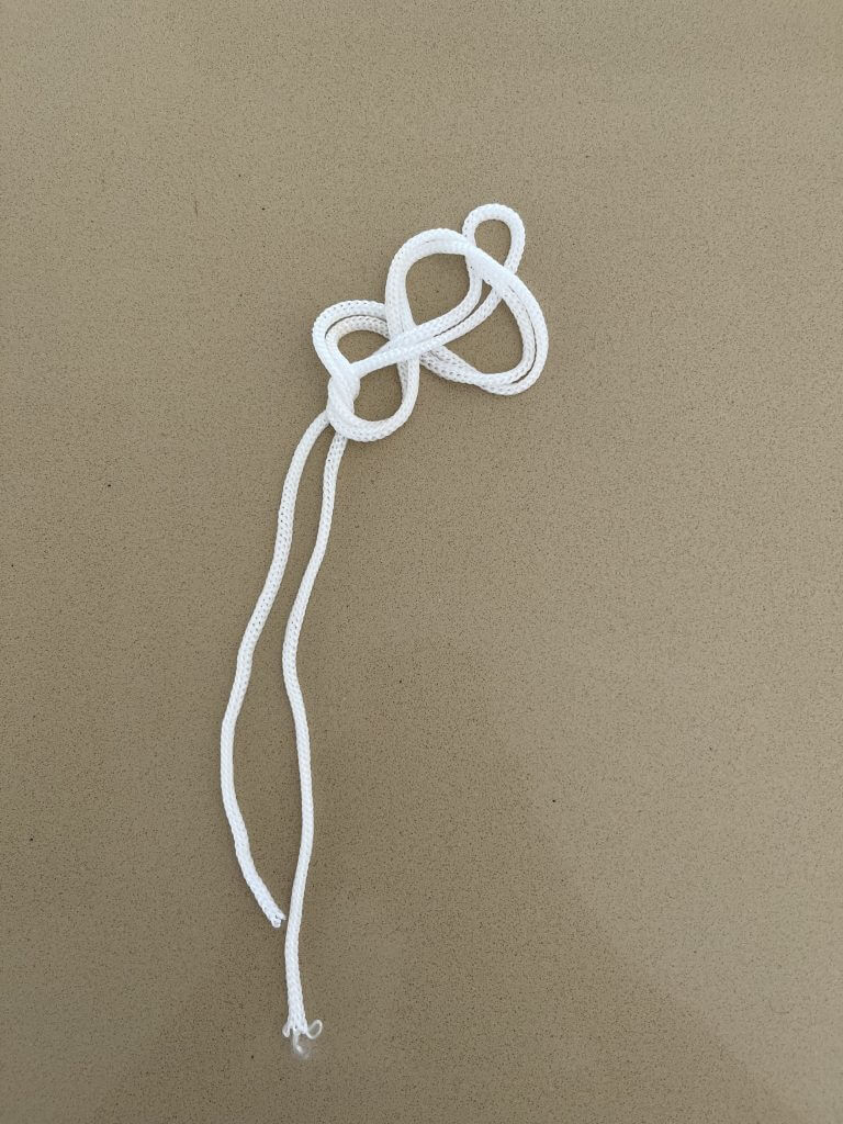 étape 5 du noeud de boucle en 8 avec une corde blanche pour faire des Nœuds Pour Moulinet de Pêche 