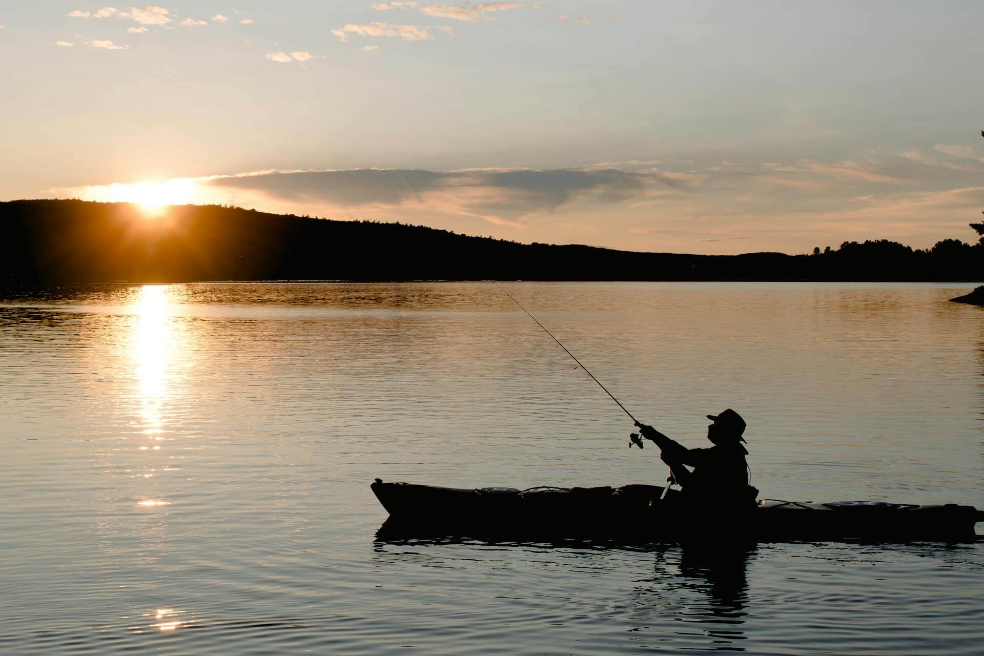 pêcheur en kayak au coucher du soleil